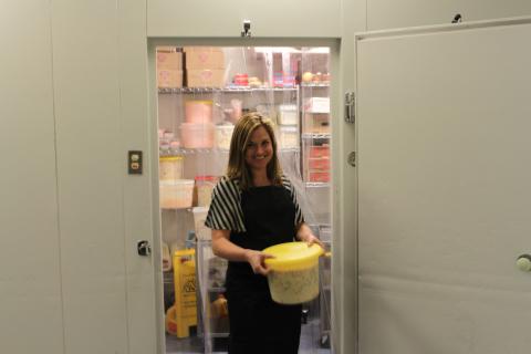 woman holding a food container on a walk-in freezer with pvc strip door curtain